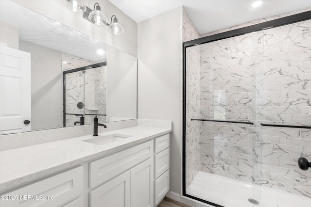 bathroom with walk in shower and vanity