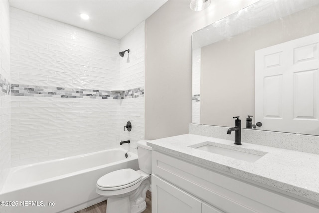 full bathroom featuring toilet, vanity, and tiled shower / bath combo