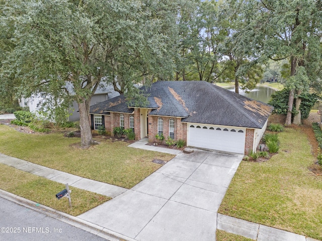 single story home with a garage, a water view, and a front lawn