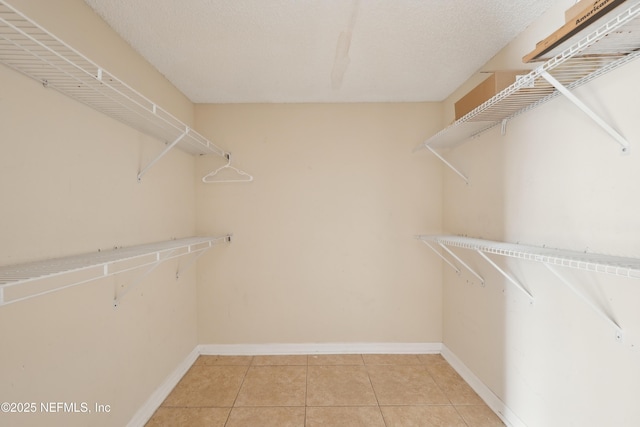 spacious closet with light tile patterned floors