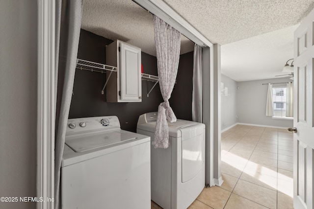 laundry room featuring cabinets, a textured ceiling, light tile patterned floors, and independent washer and dryer