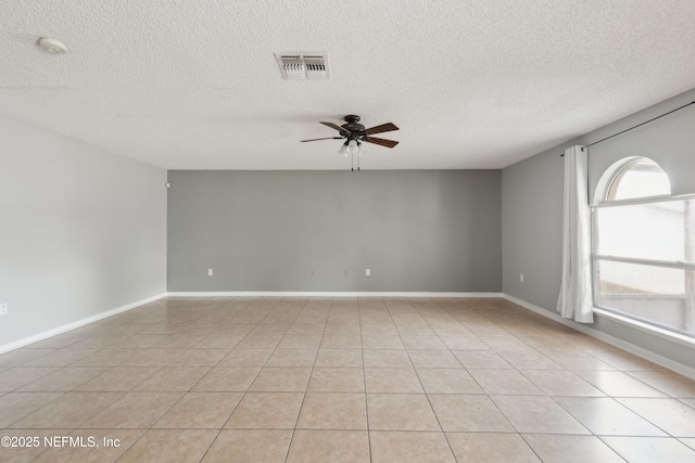 spare room featuring light tile patterned flooring, a textured ceiling, and ceiling fan