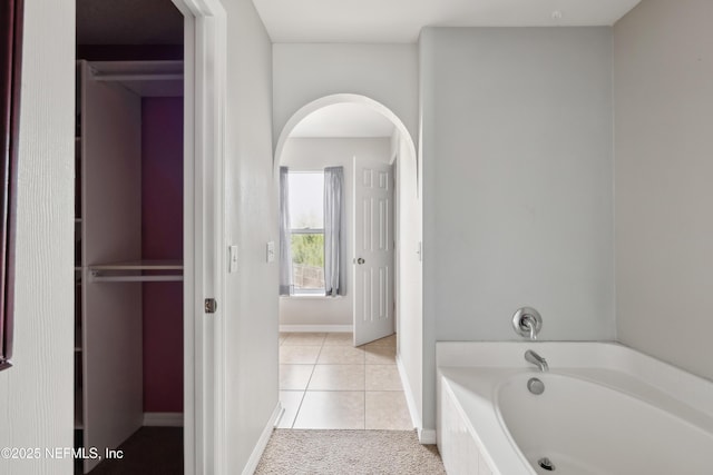 bathroom featuring tile patterned floors and a bath