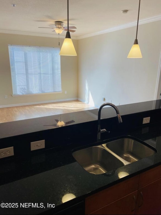 kitchen with decorative light fixtures, plenty of natural light, sink, and crown molding