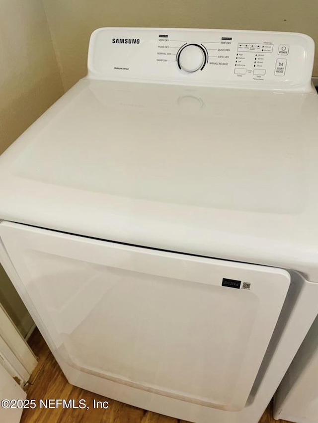 room details with washer / dryer and hardwood / wood-style floors