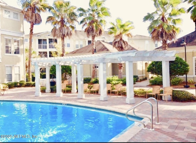 view of pool with a pergola and a patio