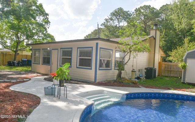 back of property featuring a fenced in pool and central AC unit