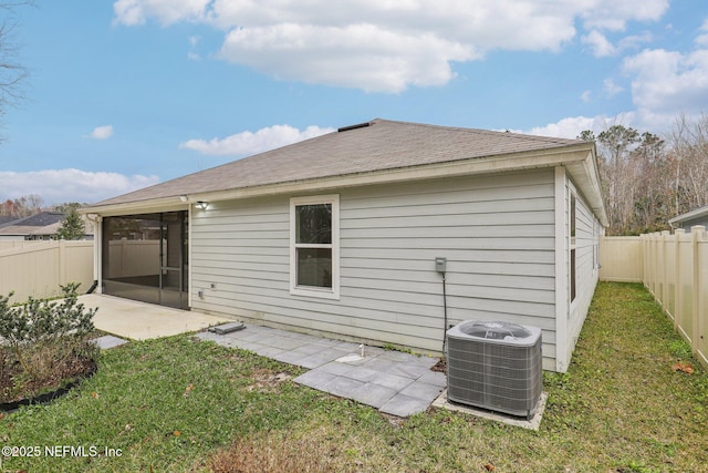 rear view of property featuring cooling unit, a patio area, and a lawn