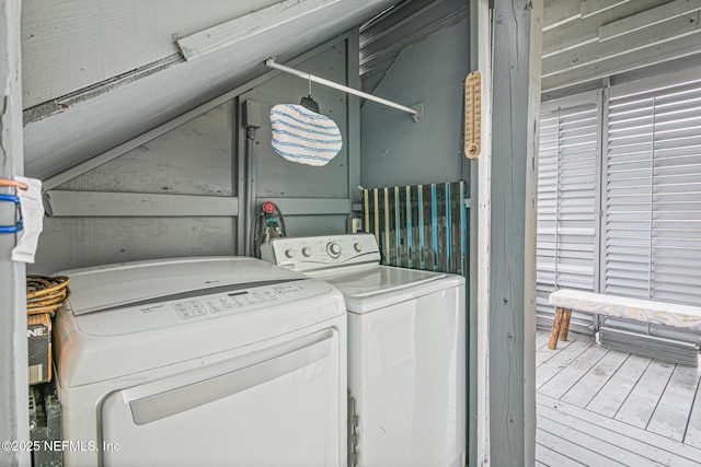 laundry area featuring wood walls and washing machine and clothes dryer