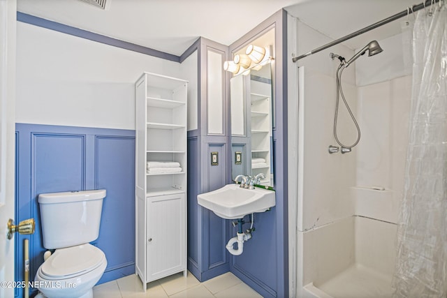 bathroom featuring sink, tile patterned floors, walk in shower, and toilet