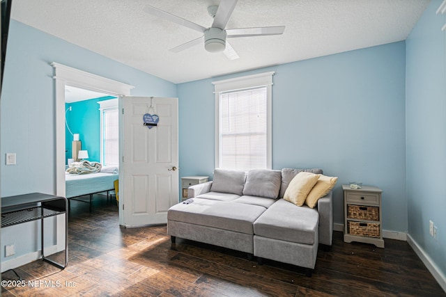 living room with ceiling fan, a textured ceiling, and dark hardwood / wood-style flooring