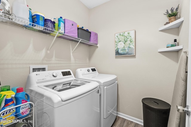 laundry room with separate washer and dryer and hardwood / wood-style flooring