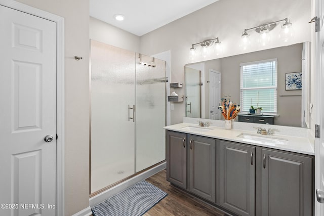 bathroom with wood-type flooring, walk in shower, and vanity