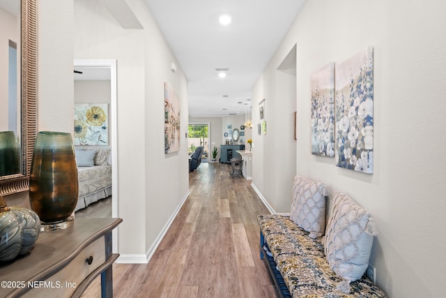 hallway with light hardwood / wood-style floors