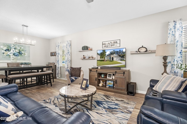 living room featuring wood-type flooring and a chandelier