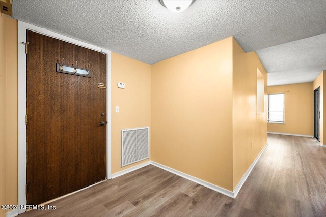 foyer with a textured ceiling and light hardwood / wood-style flooring