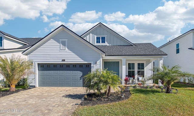 view of front of home featuring a garage, a front lawn, and a porch