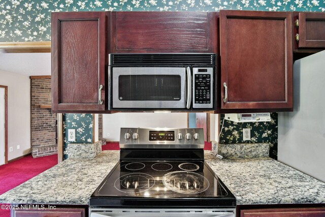 kitchen featuring appliances with stainless steel finishes and light stone counters