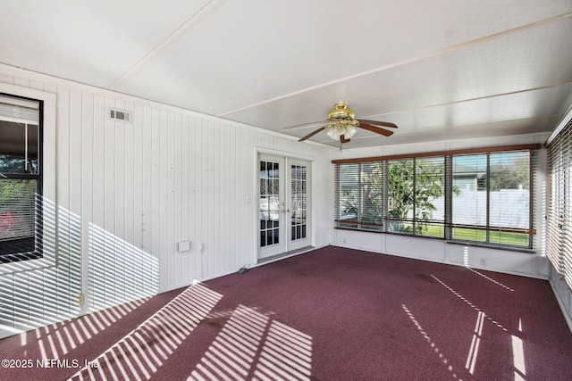 unfurnished sunroom featuring ceiling fan