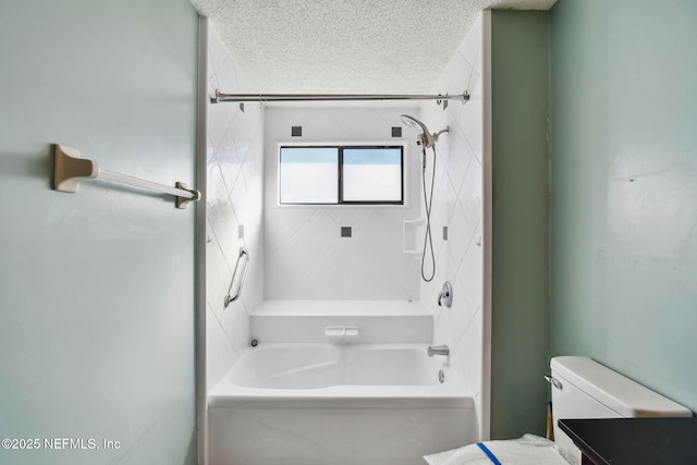 full bathroom with a textured ceiling, toilet, vanity, and tiled shower / bath