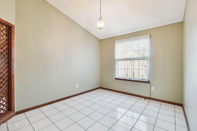 unfurnished room with light tile patterned flooring and lofted ceiling