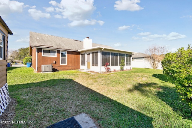 back of property featuring a lawn, central AC unit, and a sunroom