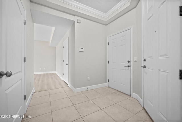 foyer with light tile patterned flooring, ornamental molding, and a textured ceiling