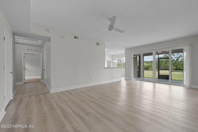 unfurnished living room with ceiling fan, a textured ceiling, and light hardwood / wood-style floors