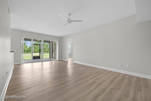 empty room featuring ceiling fan, a textured ceiling, and light hardwood / wood-style flooring