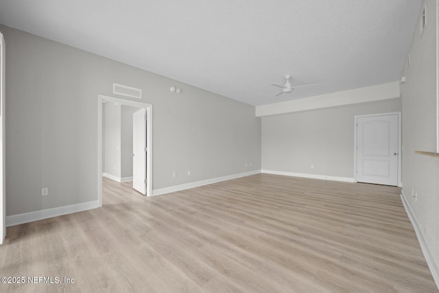 empty room with ceiling fan and light hardwood / wood-style flooring