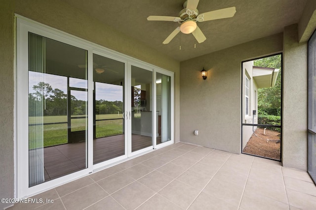 unfurnished sunroom featuring ceiling fan