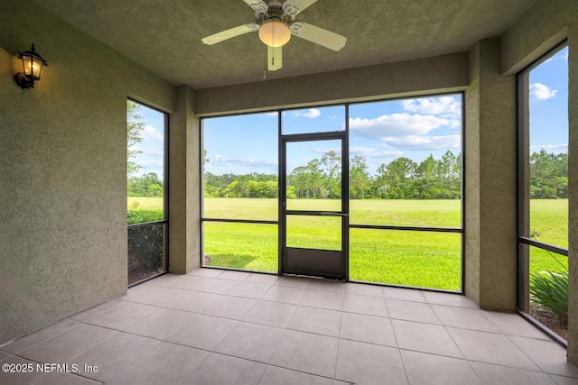 unfurnished sunroom featuring ceiling fan