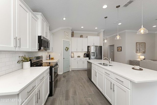 kitchen with white cabinetry, hanging light fixtures, sink, backsplash, and stainless steel appliances