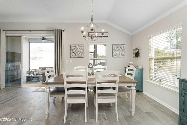 dining area with crown molding, lofted ceiling, and a notable chandelier