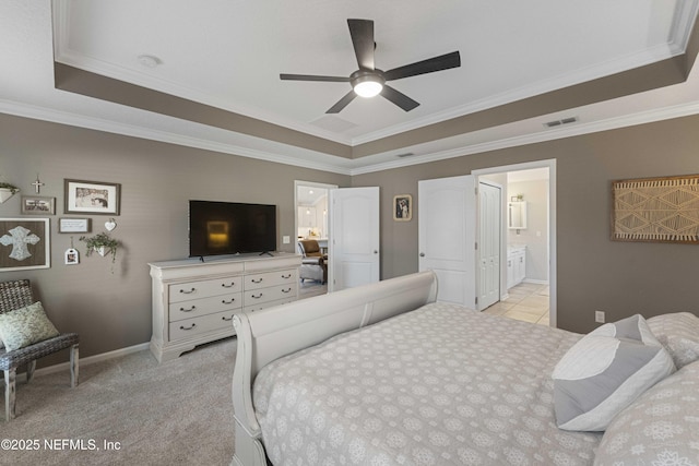 bedroom featuring light carpet, ornamental molding, ceiling fan, connected bathroom, and a tray ceiling