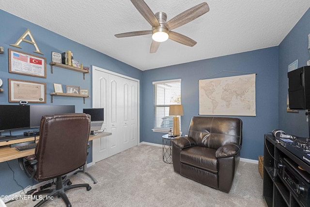 office space with ceiling fan, a textured ceiling, and light carpet