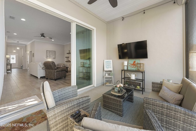 living room featuring crown molding, light hardwood / wood-style flooring, and ceiling fan