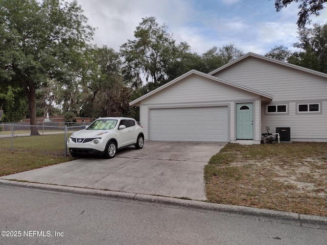 view of front of house featuring a front yard, a garage, and central AC unit