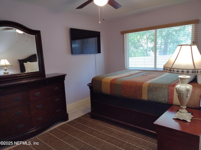 bedroom with ceiling fan and tile patterned floors