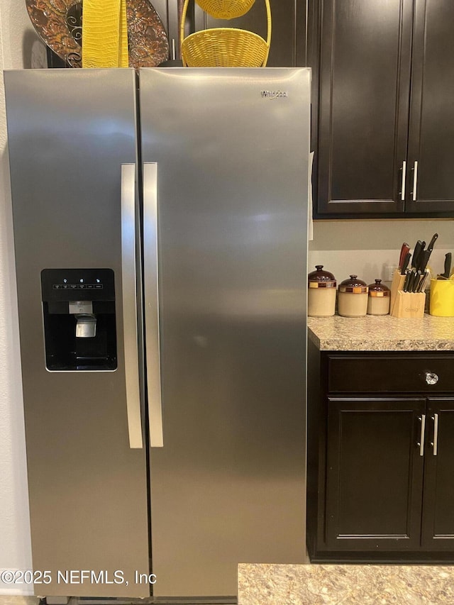 kitchen with stainless steel fridge and dark brown cabinetry