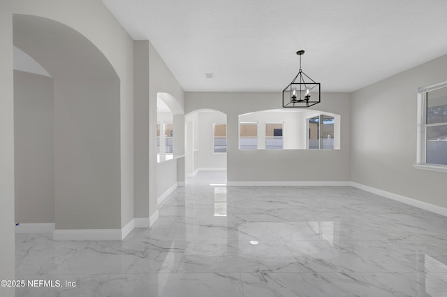 empty room featuring an inviting chandelier