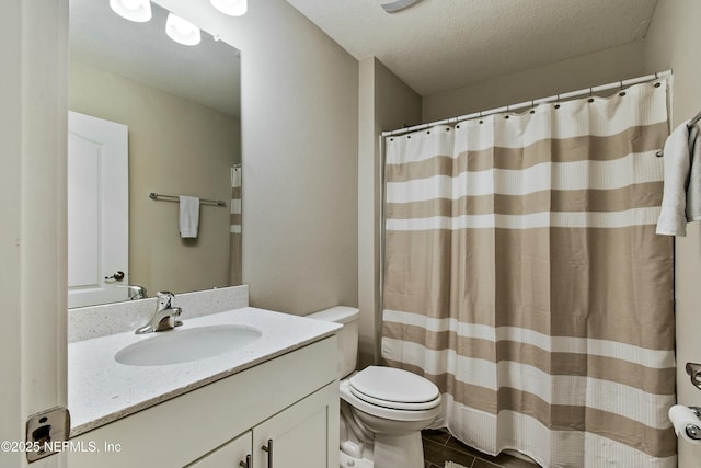 bathroom featuring toilet, vanity, a textured ceiling, and curtained shower