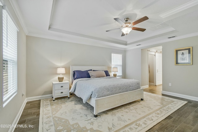 bedroom with ceiling fan, crown molding, and a raised ceiling