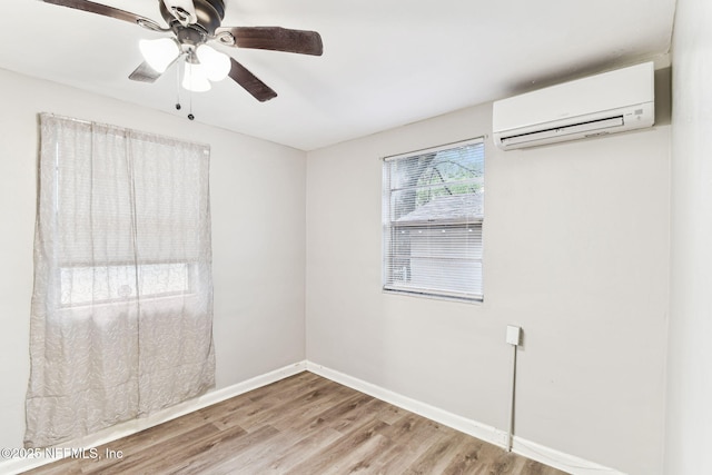 empty room with hardwood / wood-style flooring, a wall mounted AC, and ceiling fan