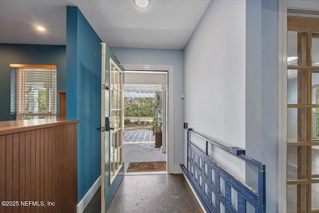 entryway featuring french doors, a healthy amount of sunlight, and a textured ceiling