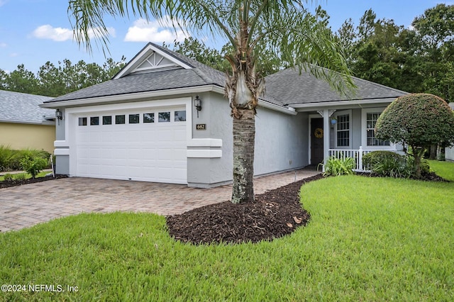 single story home featuring a garage, a front yard, and a porch