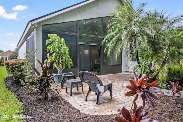 back of house featuring a sunroom and a patio