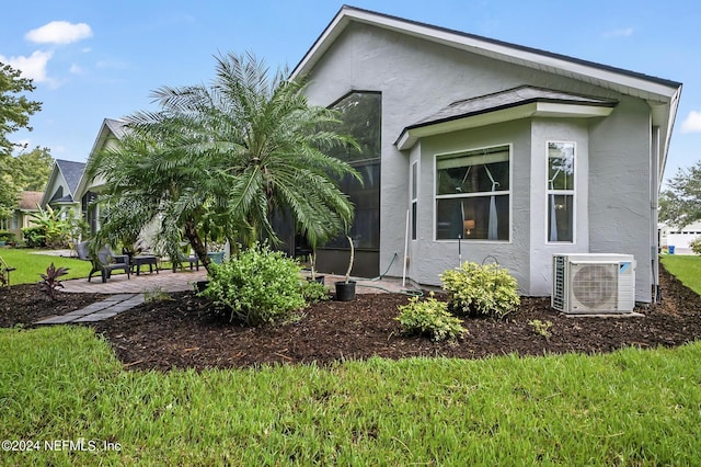 view of side of home featuring a patio area and ac unit