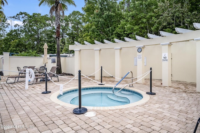 view of pool featuring a community hot tub and a patio area