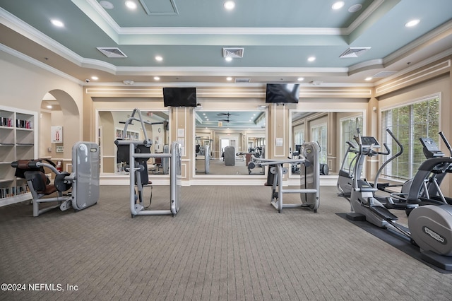 gym with ceiling fan, crown molding, carpet, and a raised ceiling